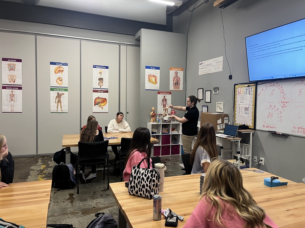Whitney Williams showing students a model of a knee in a classroom