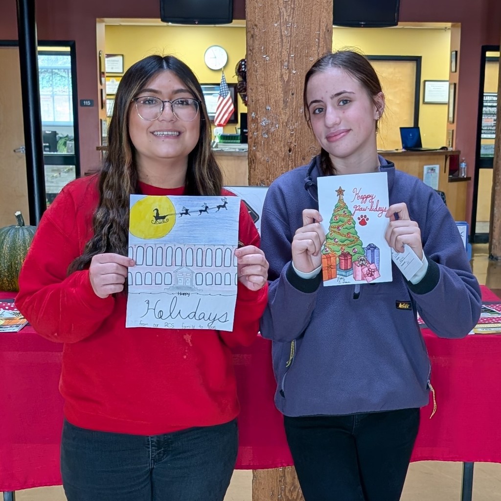 Sophia Peeples and Violet Grace both holding their holiday card designs. 