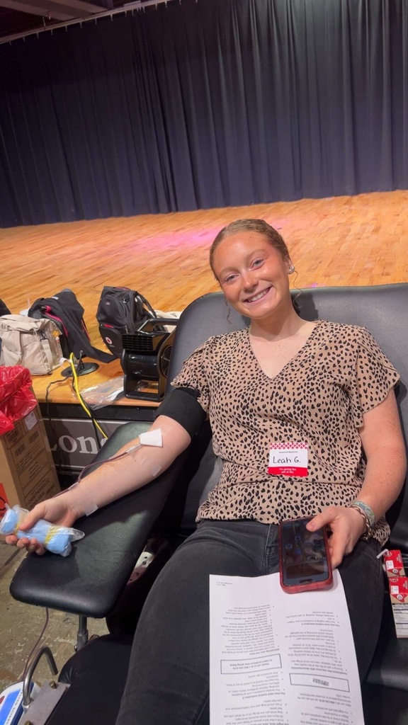 A female student sitting in a chair, giving blood. 