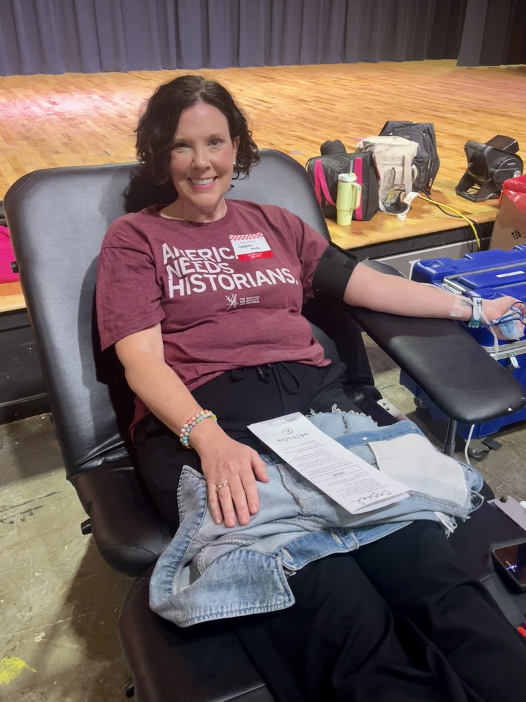 A female teacher sitting in a chair, preparing to give blood.