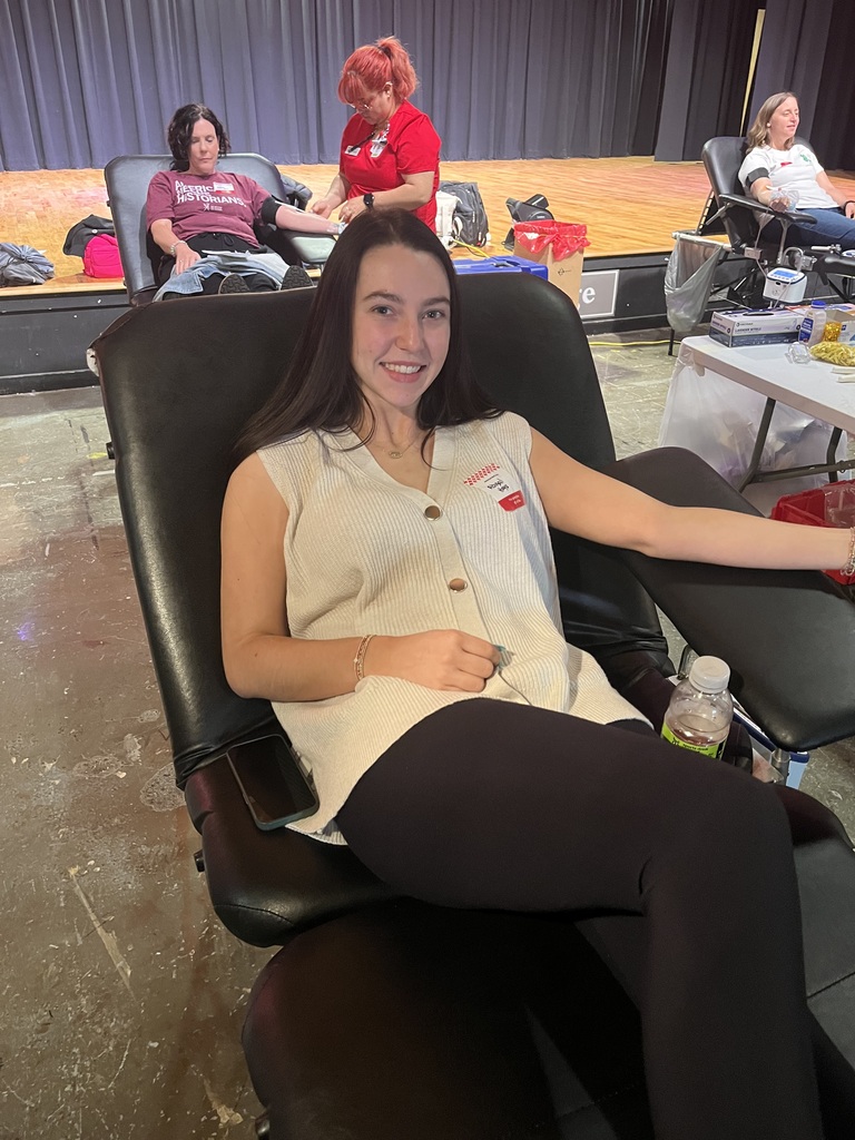 A female student sitting in a chair, preparing to give blood.
