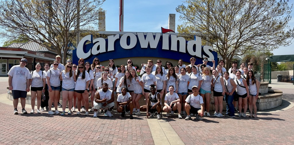 RCS band students posing in front of the Carowinds sign.