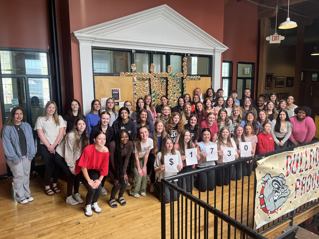 RCS HOSA students standing in front of the RCS library, holding papers saying $1,730. 