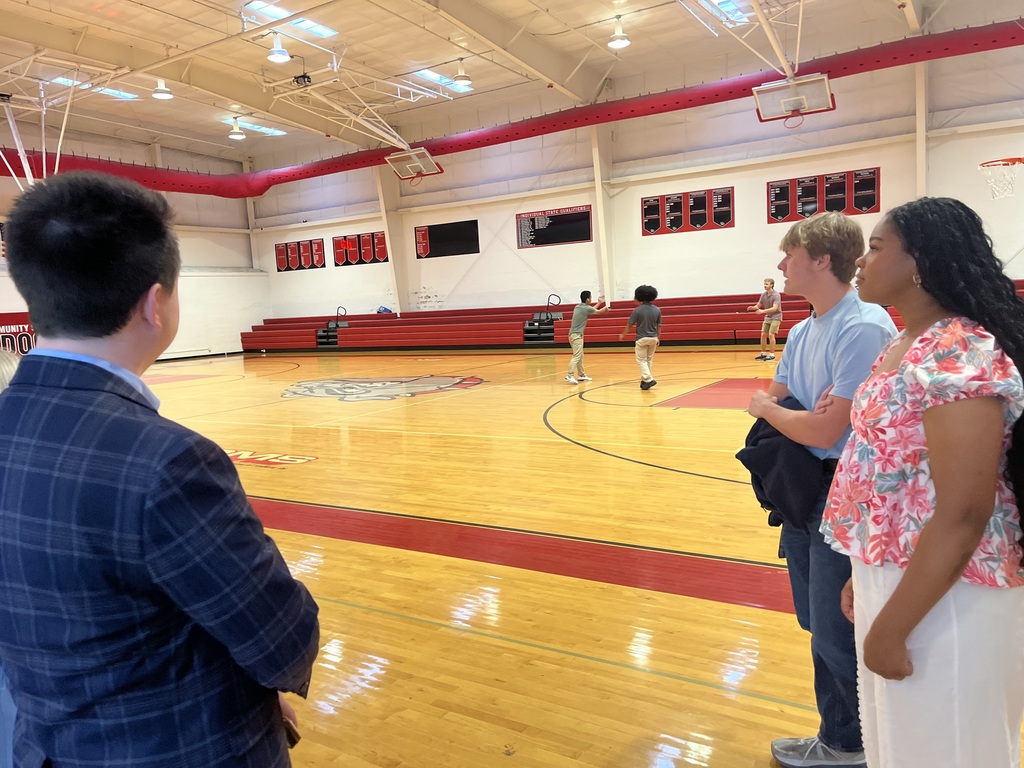 2 student talking to a man standing in the RCS gym