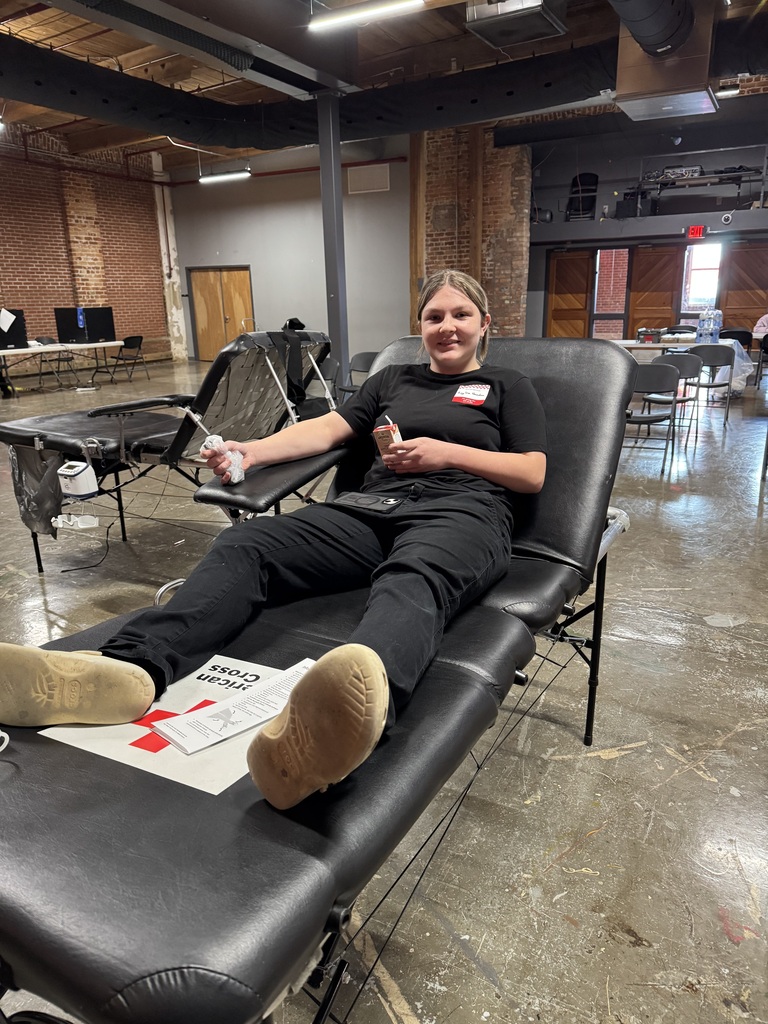 A female student laying. in a chair preparing to give blood. 