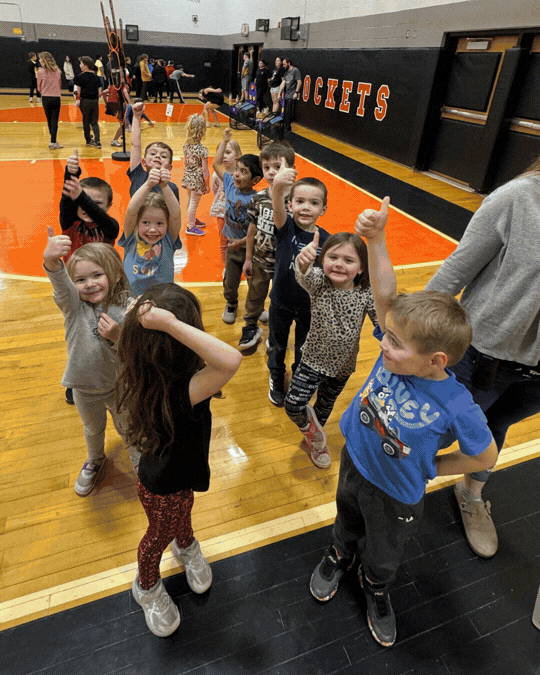 a slide show of images showing students in the gymnasium participating in events in different events such as hoola hooping, bean bag toss, and long jump.