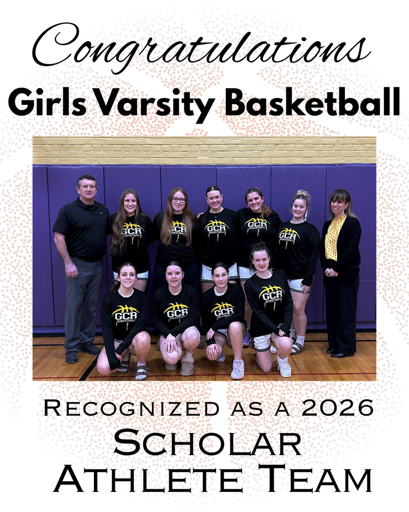 A posed team photo of the girls varsity basketball team inside a gymnasium. Players wear matching black shirts with a gold basketball logo and “GCR Basketball” across the front. Some athletes kneel in the front row while others stand behind them, with two coaches standing at the ends of the group. A purple padded wall and gym floor are visible in the background. The image includes the text “Congratulations Girls Varsity Basketball” and recognizes the team as a 2026 Scholar Athlete Team.