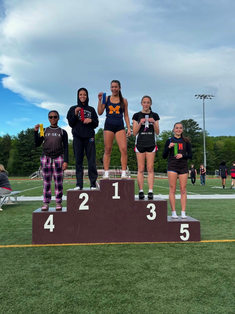 podium of track athletes standing proud with their ribbons. At the top of the podium is Roxbury's Ava Poniros proudly showing her first place win.
