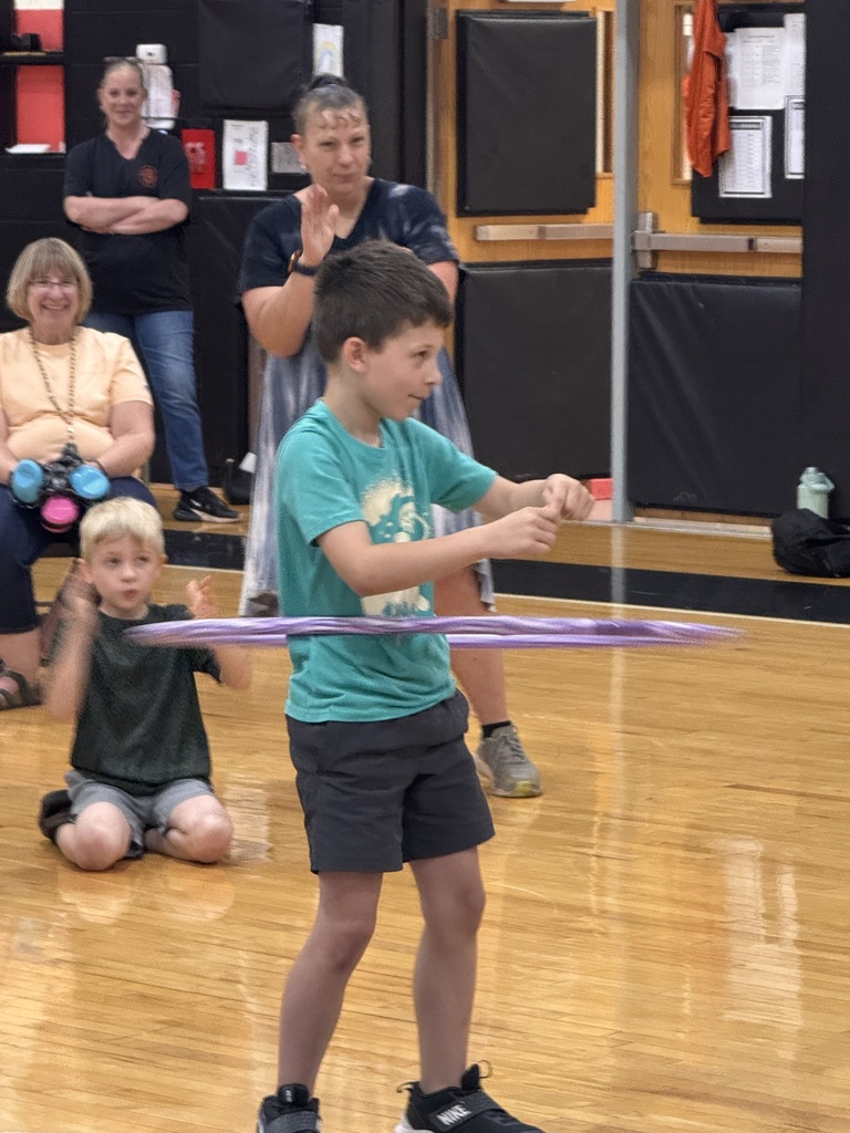 a green team member competes in a hoola hoop contest