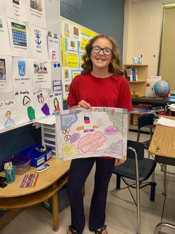 Baylee holding her poster up proudly