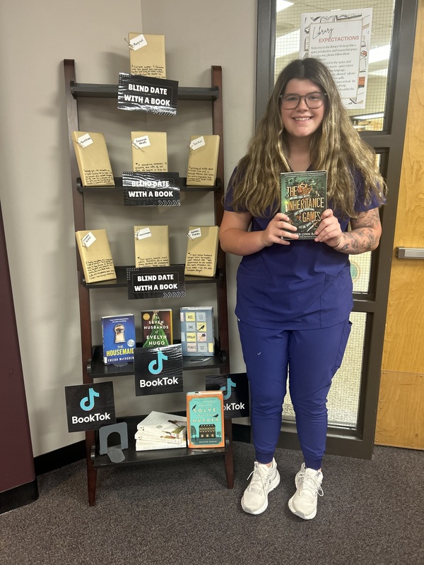 Sydney Moss holding the book she unwrapped.