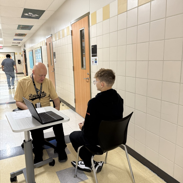 Mr. Michie having one-on-one French conversation with students  