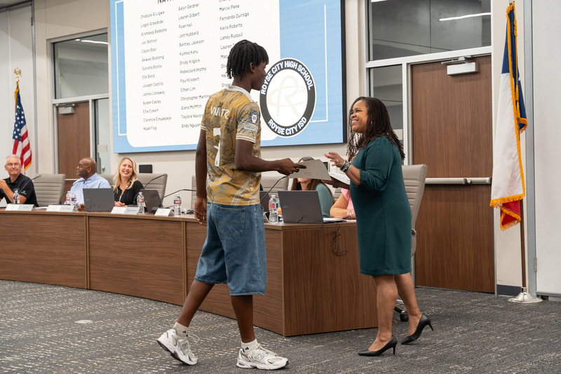 Dr. Squalls presenting a certificate to a student