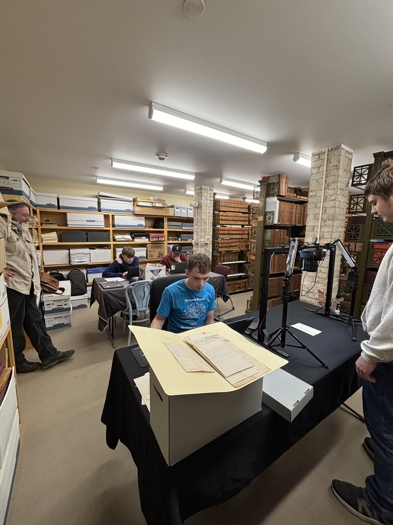 Mr. Viles looks on while students go through archives