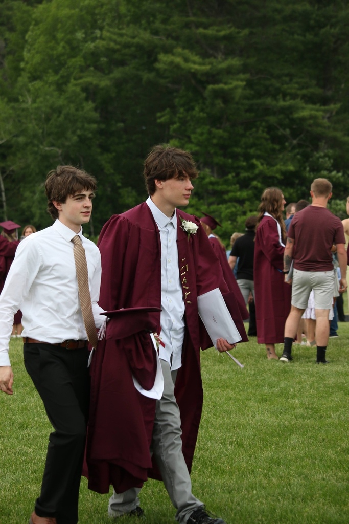 Recent graduates walk the grounds with graduation caps in hand. 