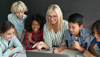 Students and Teacher gathered around a computer