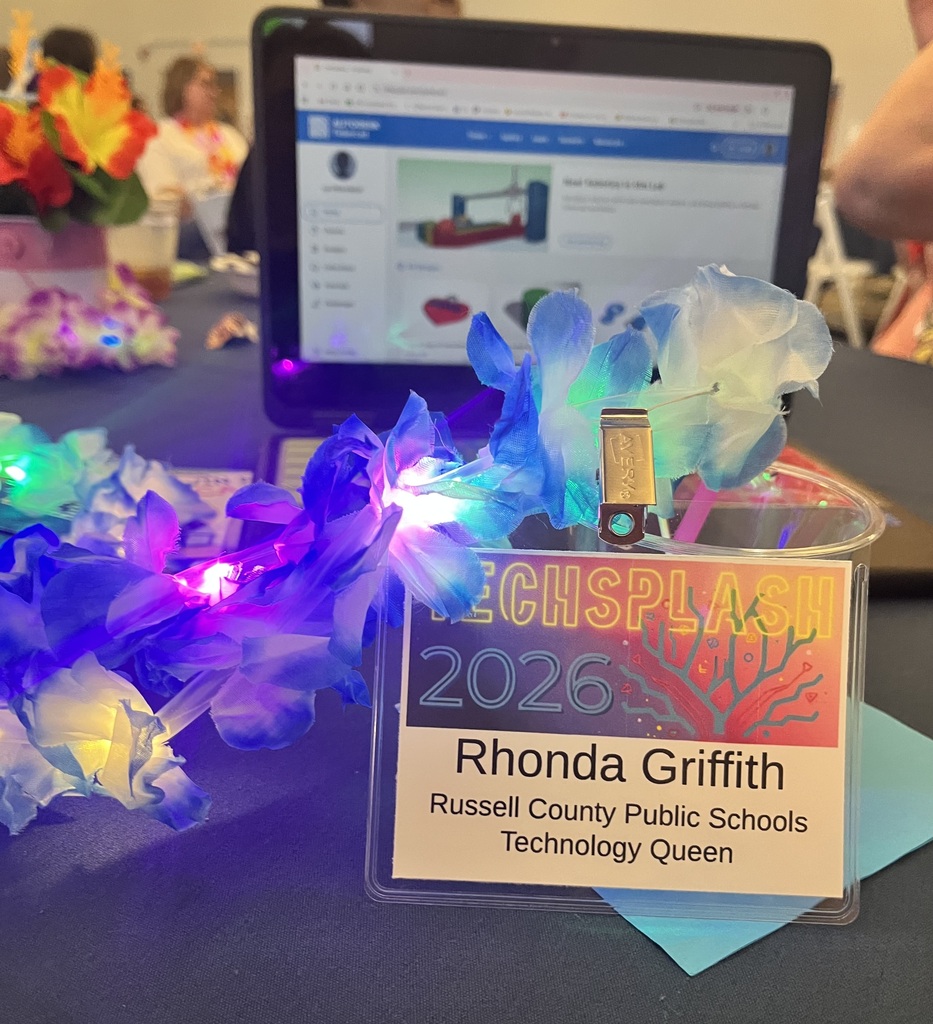 Ms. Griffith, Technolgy Queen, highlights her badge and lei at TechSplash.