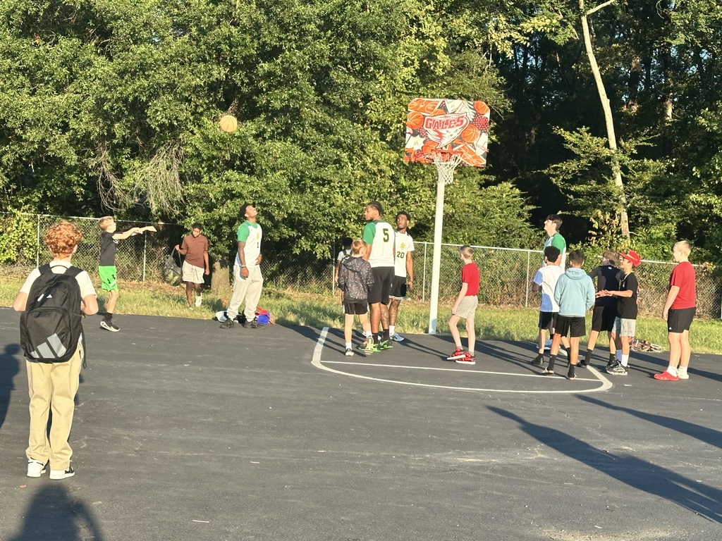 athletes playing basketball with the students