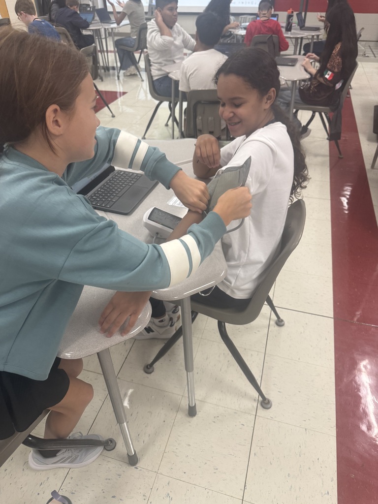 a student helping others put on a blood pressure cuff