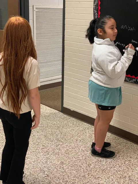 Student signing brag board 