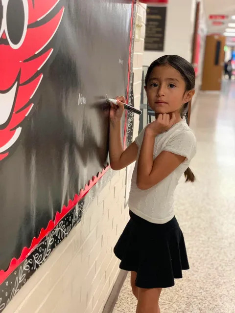 Student signing brag board 