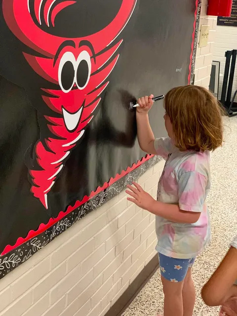 Student signing brag board 
