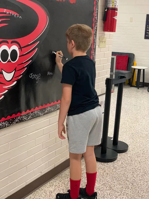 Student signing brag board 