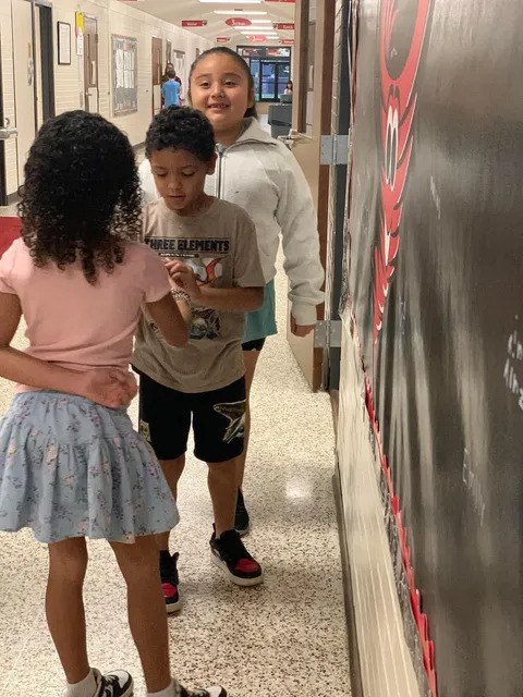 Student signing brag board 