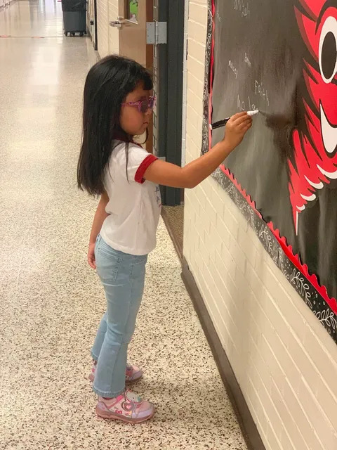 Student signing brag board 