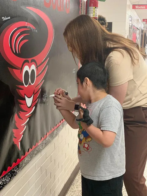 Student signing brag board 