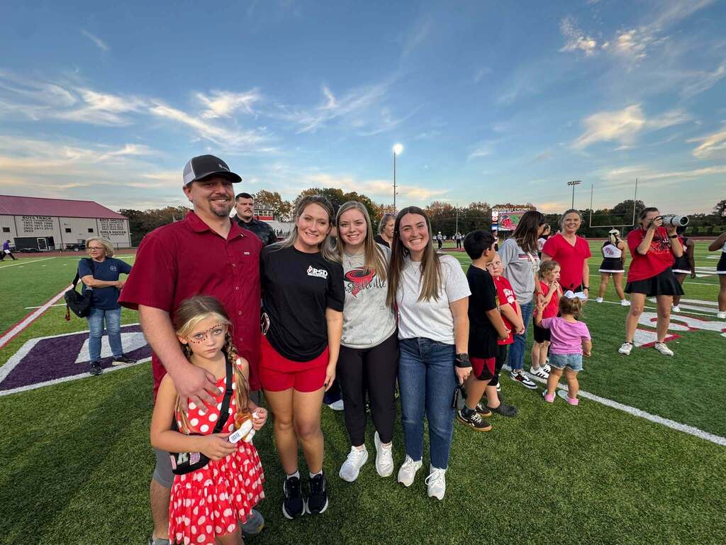 group of people standing on a football field