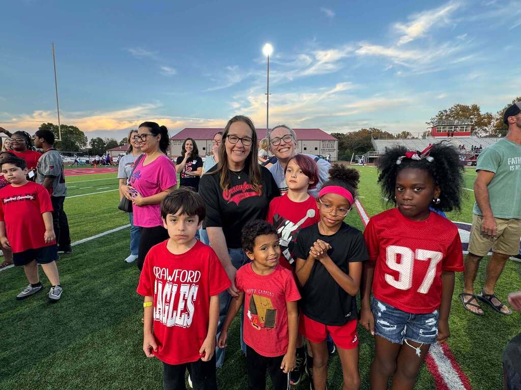 group of people standing on a football field
