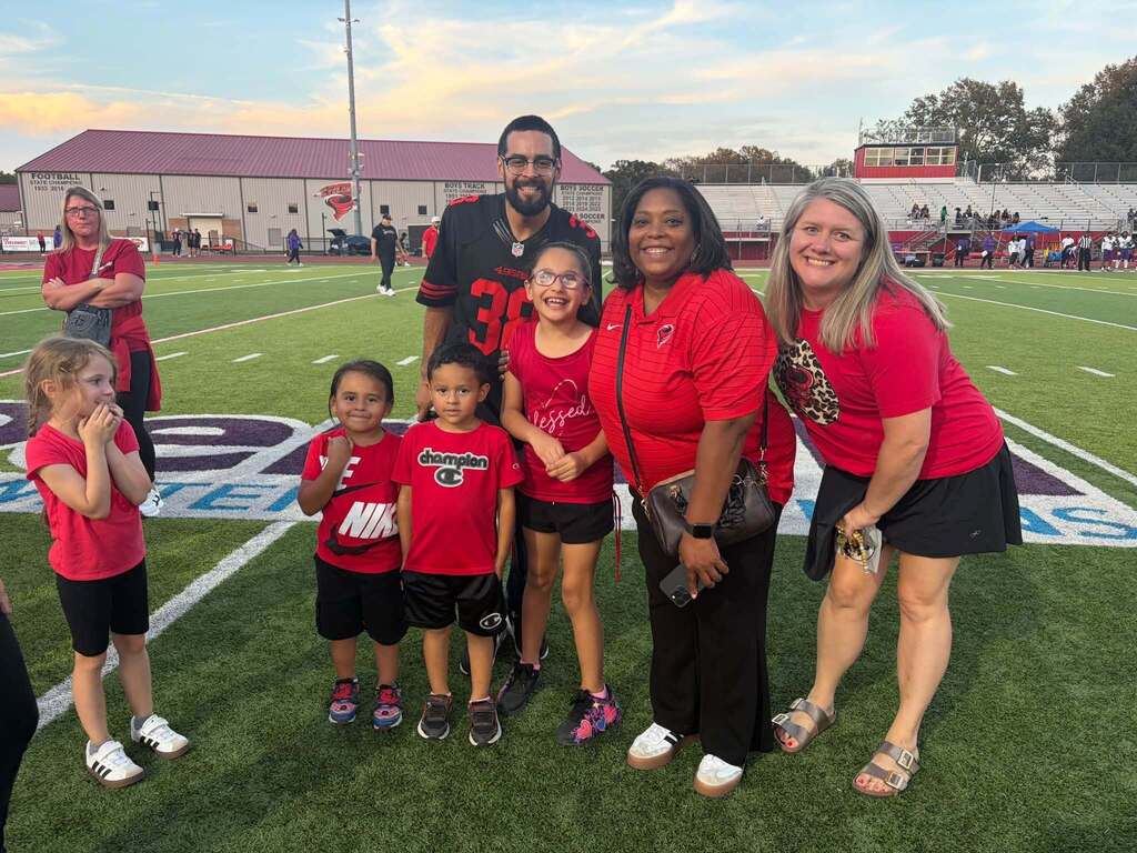 group of people standing on a football field