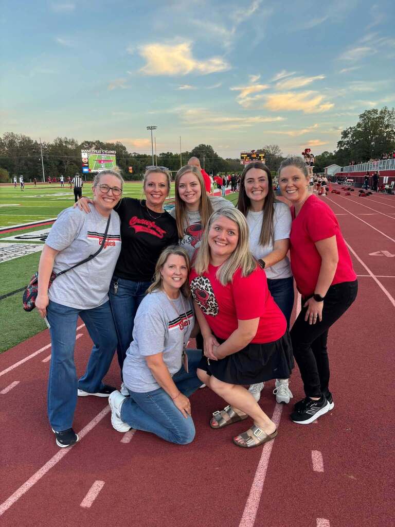 group of people standing on a football field