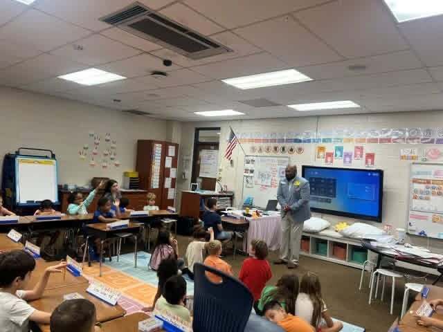 man standing at the front of a classroom