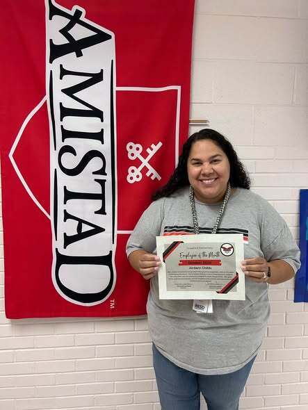 woman standing with employee of the month certificate