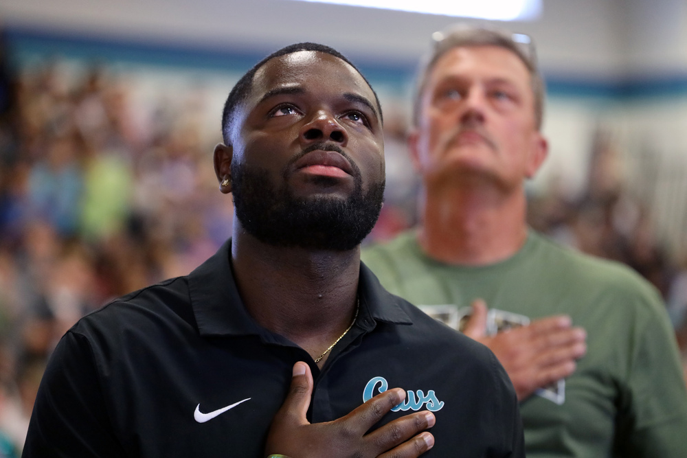 Young african american male holds hand over heart