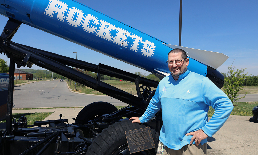 Principal Luker standing outside school with Rocket