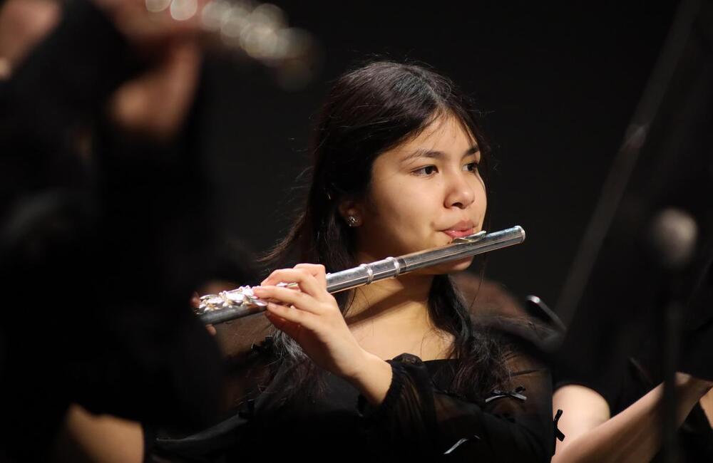 Girl playing silver fluete in concert setting