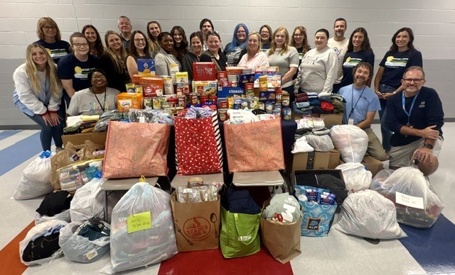 Group posing around donated items in bags
