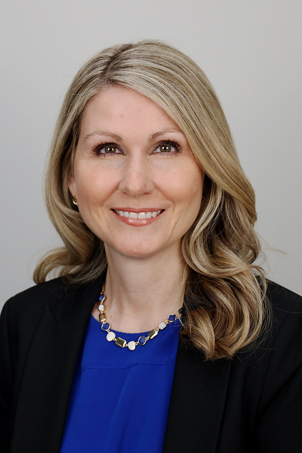 Woman with blonde hair wearing black blazer and blue shirt