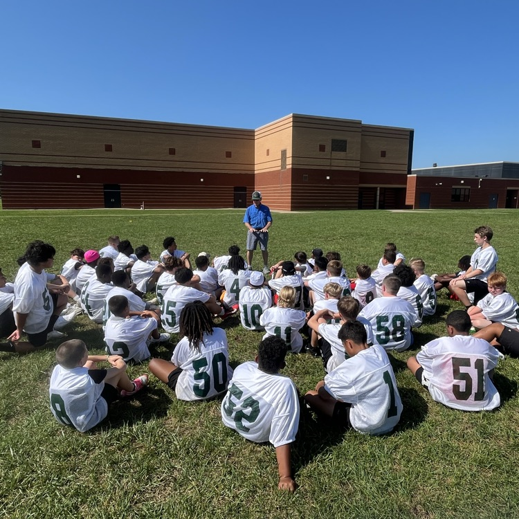 man talking to group of students outside 