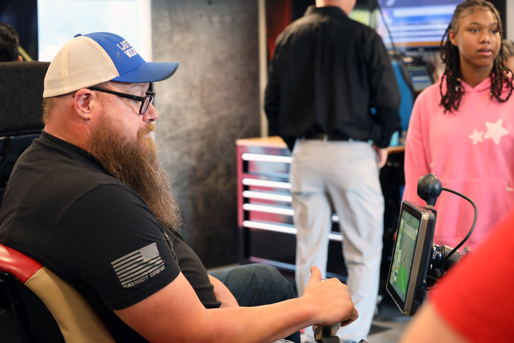 Teacher in blue cap operates simulator