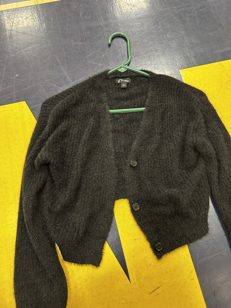 A gray cardigan with buttons is hanging on a green hanger against a yellow and gray background.