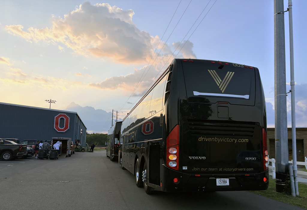 A charter bus is parked outside the Oakland foobal field house