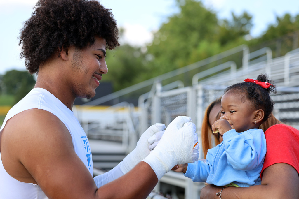 football player fistbumps toddler