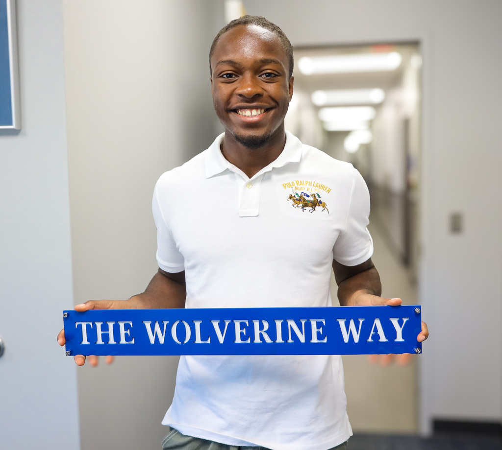Student hold sign that says, "The Wolverine Way"