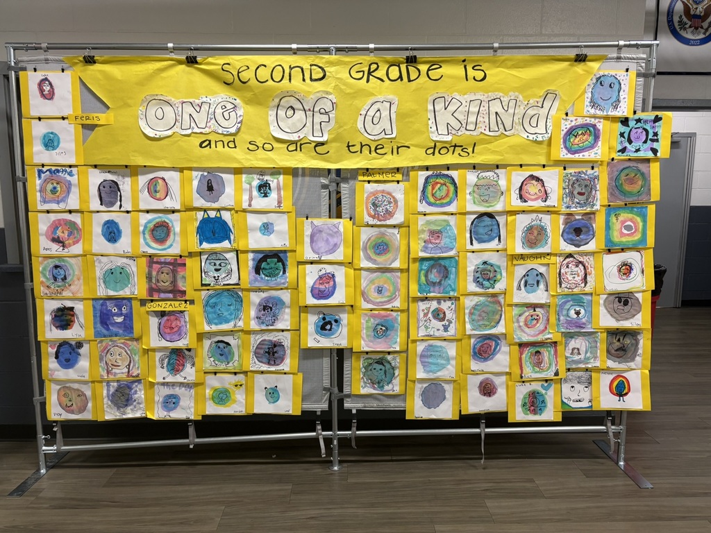 A display with a yellow banner saying "Second Grade is One of a Kind" and multiple colorful circular artworks on it.