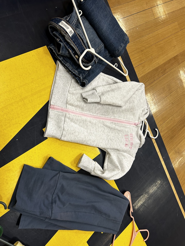 Two sets of clothing on a mat. One set has a hoodie and pants, and the other has a jacket and jeans.