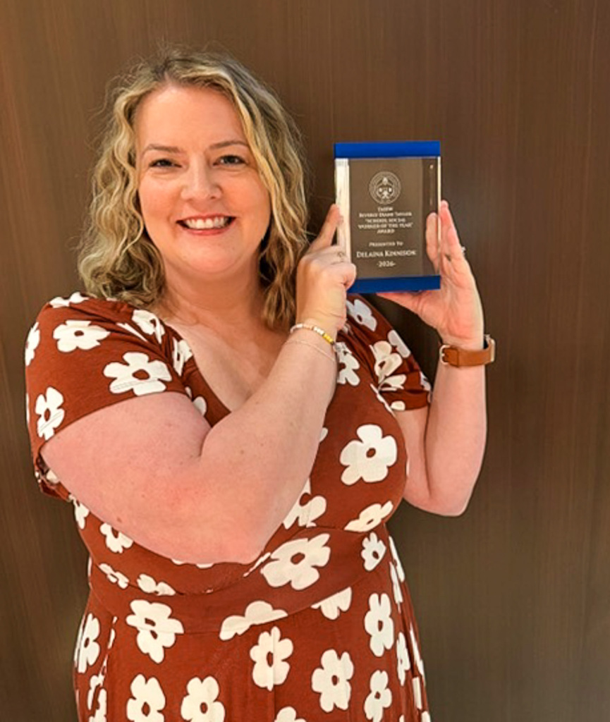 Delaina Kinnison holding her award